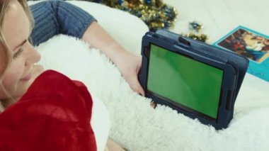 Anne yeşil ekran ile dokunmatik yüzey ile a Noel öykü okur