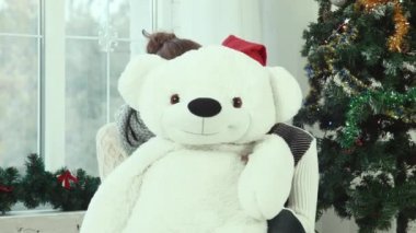 Ayı saklanarak ve kameraya gülümseyen iki genç kız