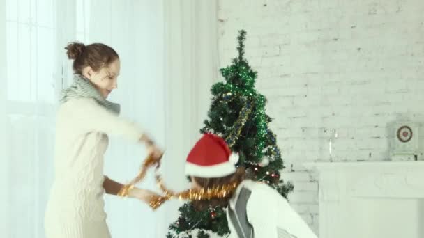 Zwei Freundinnen tragen einander Weihnachtsmützen — Stockvideo