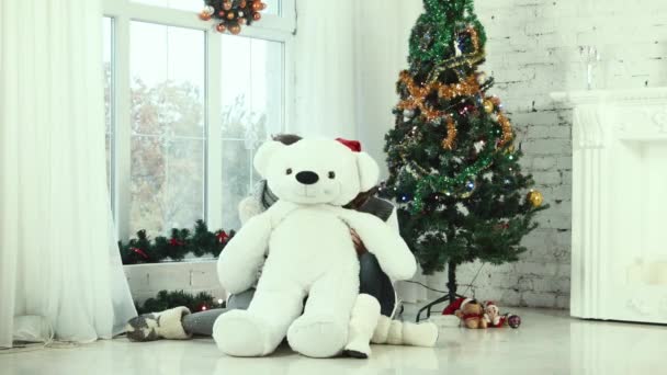 Two teen girl hiding behind the bear and smiling at the camera — Stock Video