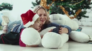 Anne dokunmatik yüzey ile a Noel öykü okur