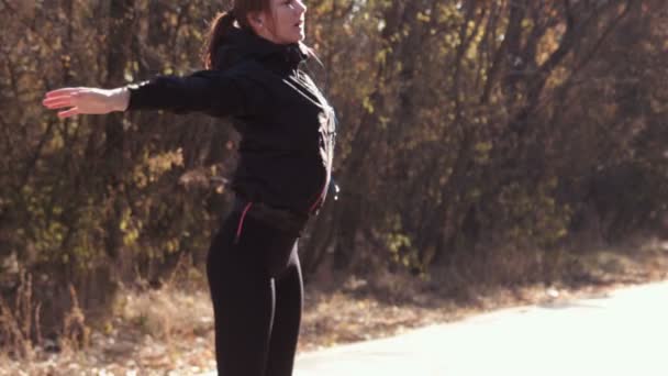 A menina faz exercícios no parque de outono — Vídeo de Stock