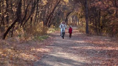 Anne ile çocuk sonbahar Park bisiklet sürmek