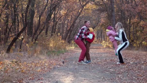 Le felici passeggiate in famiglia nel parco autunnale — Video Stock