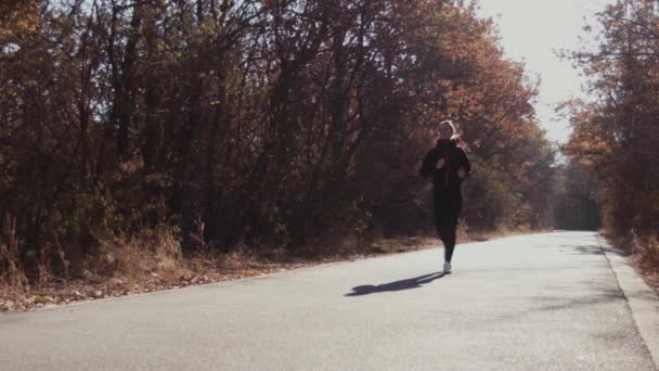 A menina que corre no parque de outono . — Vídeo de Stock