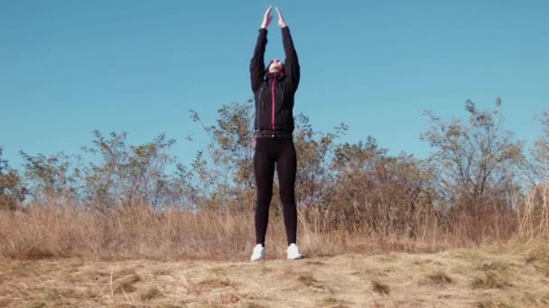 Девушка делает упражнения в осеннем парке — стоковое видео