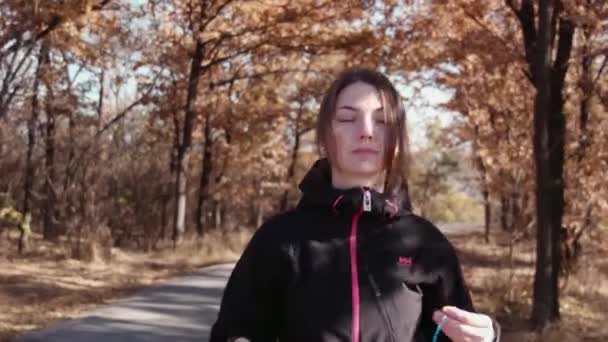 Het meisje wordt uitgevoerd in de herfst park — Stockvideo