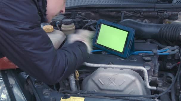 Чоловік перевіряє двигун за допомогою сенсорної панелі зеленим кольором — стокове відео