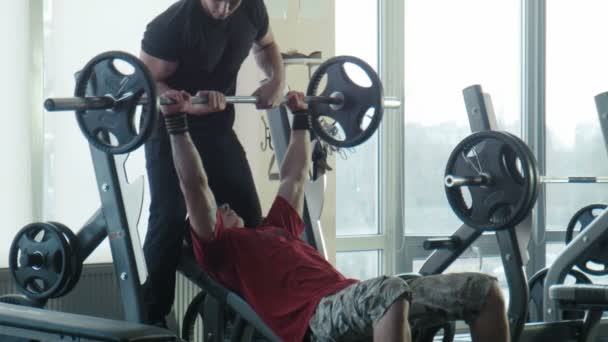 O fisiculturista faz exercício com uma barra — Vídeo de Stock