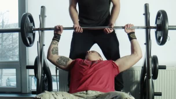 The bodybuilders does exercise with a bar — Stock Video