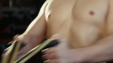 Adam bir spor salonu egzersiz makinesi üzerinde çalışmaktadır