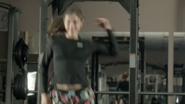 Die Frau betreibt Fitness in einem Fitnessstudio — Stockvideo