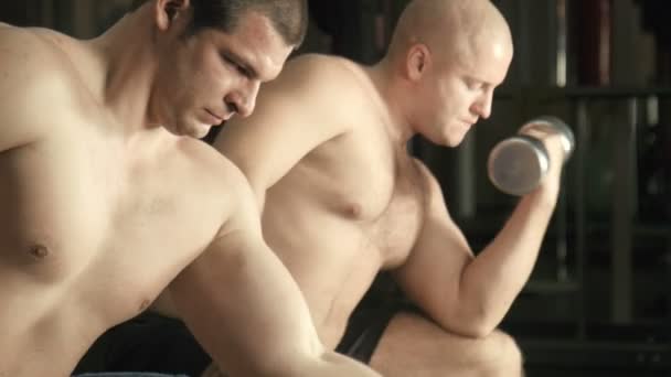 Dos hombres entrenan en un gimnasio — Vídeos de Stock