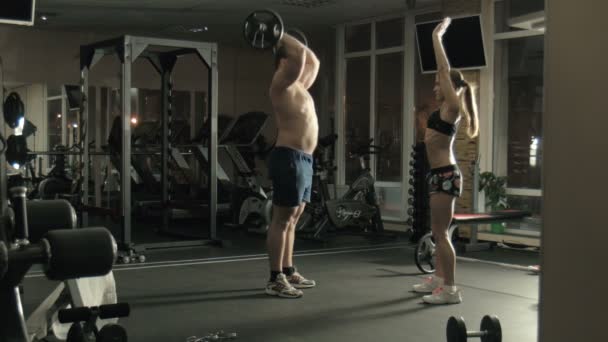 Человек тяжелоатлет поднимает бар в тренажерном зале — стоковое видео