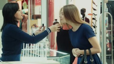 Kızlar alışveriş merkezinde parfüm seçer