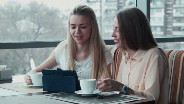 La muchacha muestra a la amiga algo en el touchpad — Vídeos de Stock