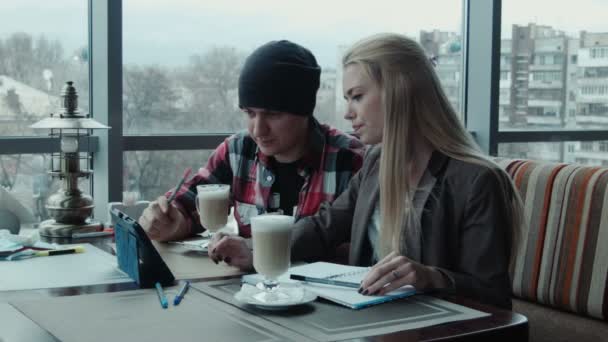 Designers freelances discuter du projet en utilisant la tablette dans le café — Video