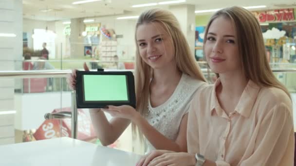 Duas meninas mostram o tablet com a tela verde — Vídeo de Stock