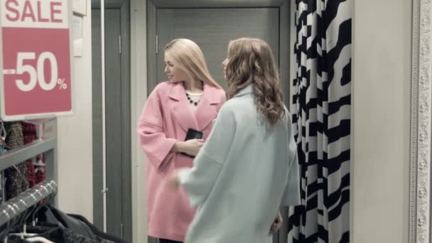 Deux filles essaient un manteau dans un vestiaire — Video