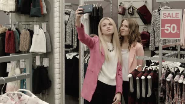 Девушки делают селфи в магазине одежды — стоковое видео