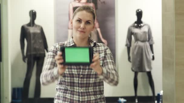 A lány megmutatja a tabletta-val a zöld képernyő Mall — Stock videók