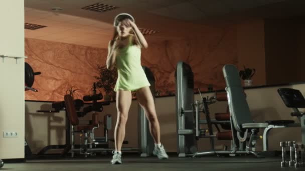 Mujer está haciendo movimientos de lucha con pesas en gimnasio de fitness . — Vídeos de Stock