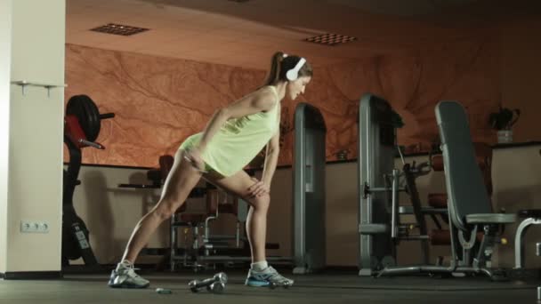 Mujer está haciendo ejercicios con pesas en gimnasio pilates fitness . — Vídeo de stock