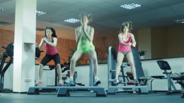 Клас аеробіки робить стрибки на кроках разом — стокове відео