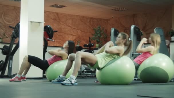 Dames uitoefenen op oefening ballen in fitness gym — Stockvideo