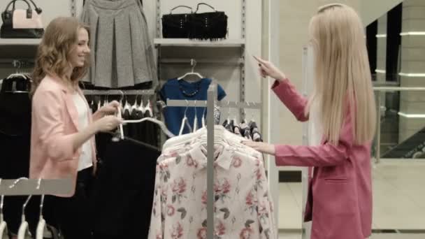 Zwei Mädchen wählen ein Kleid — Stockvideo