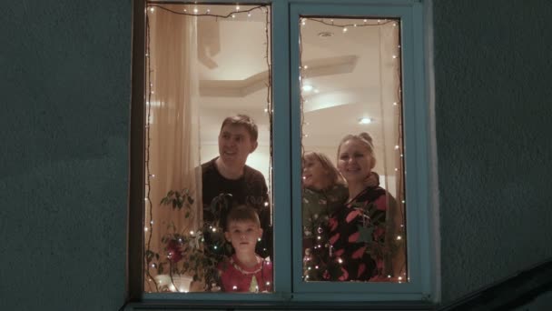 Navidad, familia feliz cerca de una ventana — Vídeo de stock