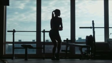 Çekici kadın silüeti teşkil etmektedir ve bir jimnastik salonu kas gösterir