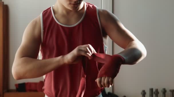 The young boxer wrap red bandage on hands — Stock Video