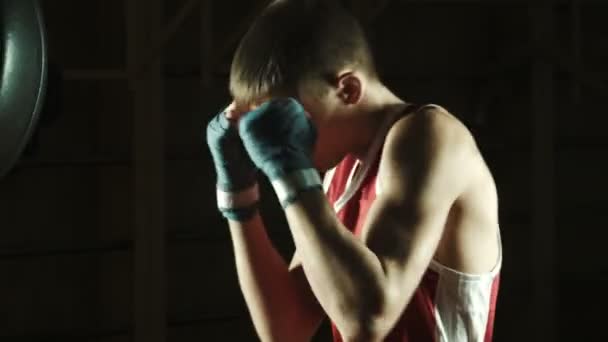 Jeune caucasien Boxer entraînement avec un sac de boxe dans la salle de gym — Video