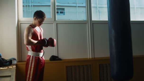 El joven boxeador entrenando en gimnasio con saco de boxeo — Vídeo de stock