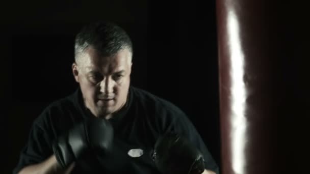 Silhouette of boxer hitting the punching bag — Stock Video