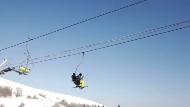 Two skiers riding up ski lift — Stock Video