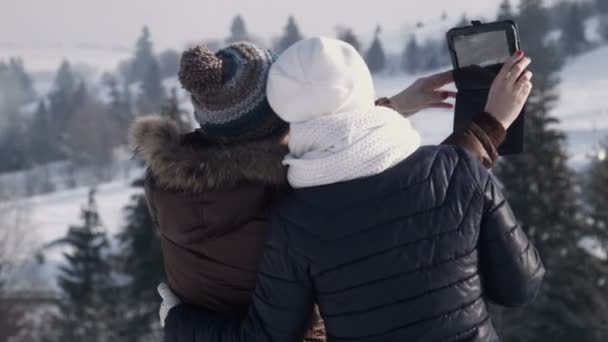 Подружки делают селфи на горе с помощью планшета — стоковое видео