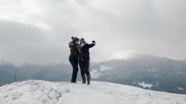 Dos novias hacen selfie en la cima de la montaña — Vídeo de stock