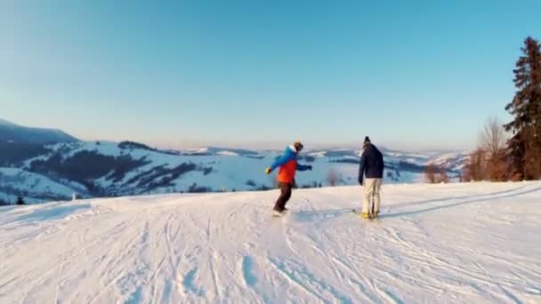 Two snowboarders climbs down a mountain — Stock Video