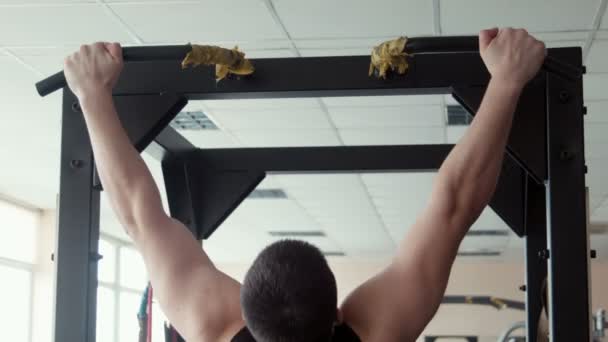 Κοντινό πλάνο αρσενικό bodybuilder τραβώντας προς τα επάνω σε ένα γυμναστήριο — Αρχείο Βίντεο