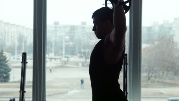 Силуэт спортсмен поднимает штангу в спортзале — стоковое видео