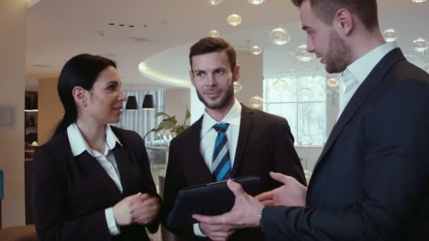 Three businessmen communicate in the hall — Stock Video