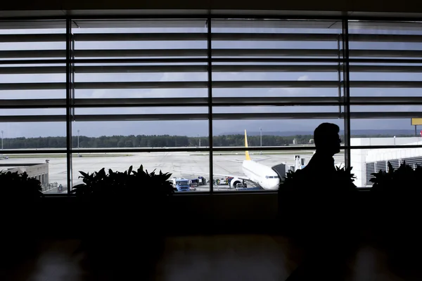 Silhueta homem esperando avião no lounge do aeroporto — Fotografia de Stock