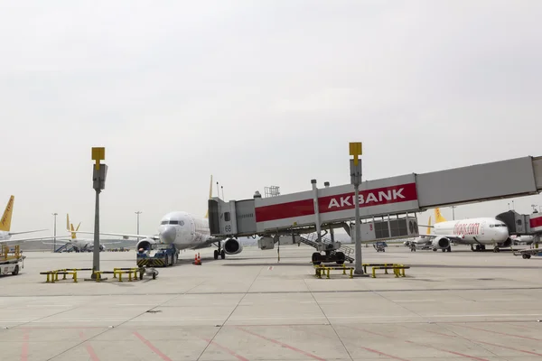 Ponte de embarque de passageiros ligada ao avião no aeroporto — Fotografia de Stock