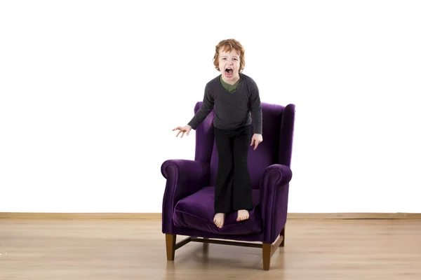 Niño rabietas enojado gritando en un sillón — Foto de Stock