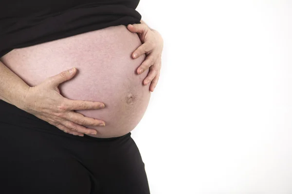 Grávida segurando barriga perto isolado no fundo branco — Fotografia de Stock