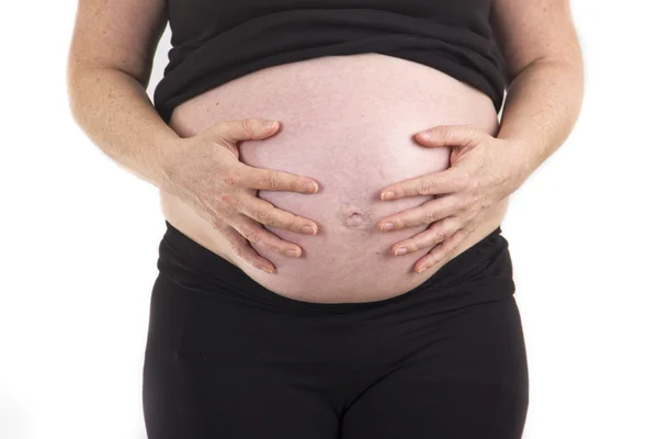 Kobieta w ciąży brzuch gospodarstwa z bliska na białym tle — Zdjęcie stockowe