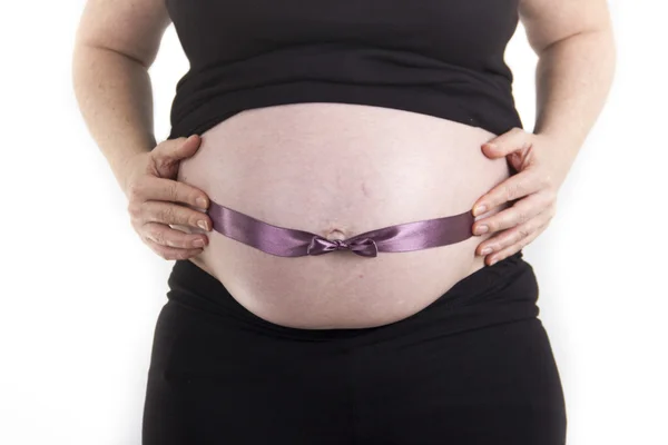 Pregnant belly with ribbon bow isolated on white background — Stock Photo, Image