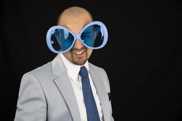 Businessman wearing big funky glasses isolated on black background — Stock Photo, Image